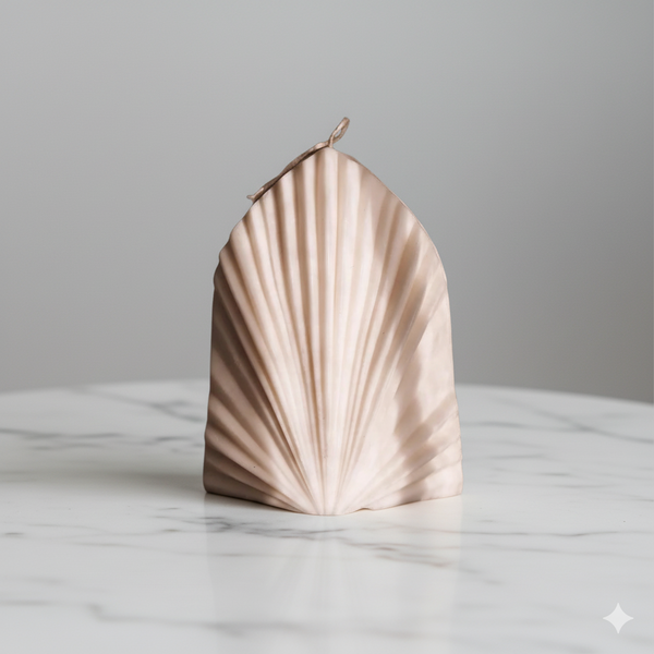 Shell-shaped candle on a marble surface with a grey background. Great gift idea