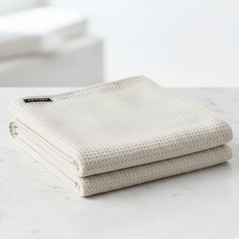 Folded beige towel on a white marble surface