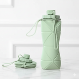 Collapsible green silicone water bottle with carrying strap on a white background