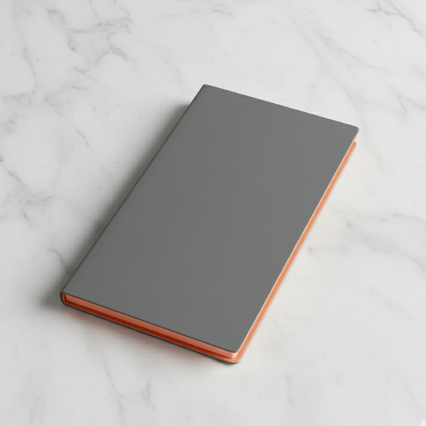 Grey notebook with copper edge on a marble surface